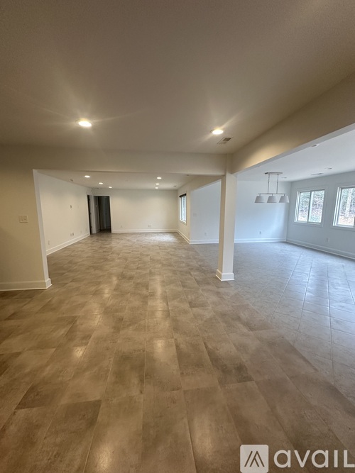 A spacious room with wooden flooring and a high ceiling.