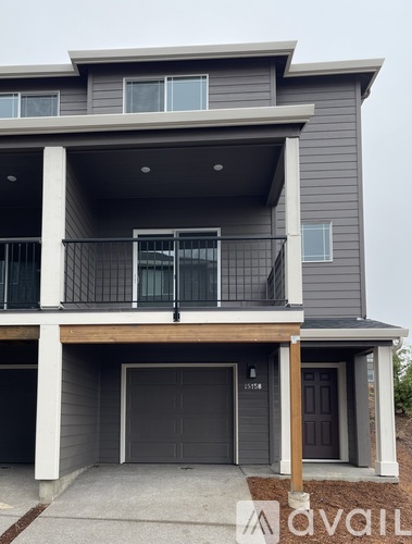 A modern two-story house with a balcony and garage.