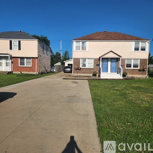 A sunny day at a residential area with houses and a driveway.