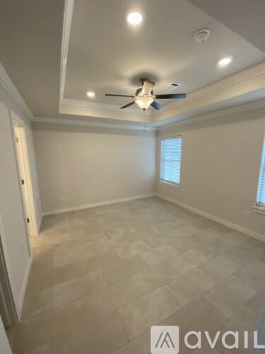 A room with a ceiling fan and tiled flooring.