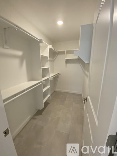 A white pantry with shelves and a cabinet.