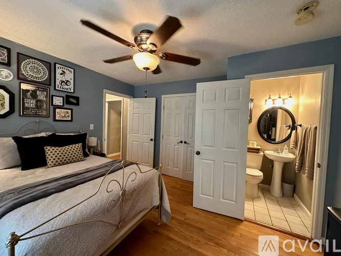 A bedroom with a bed, a mirror, and a ceiling fan.