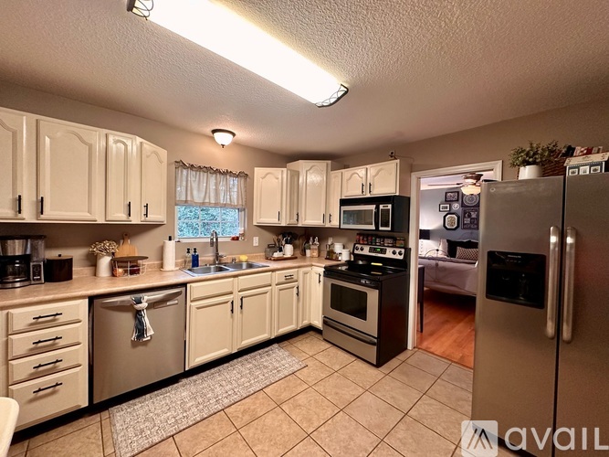 A kitchen with white cabinets and appliances.