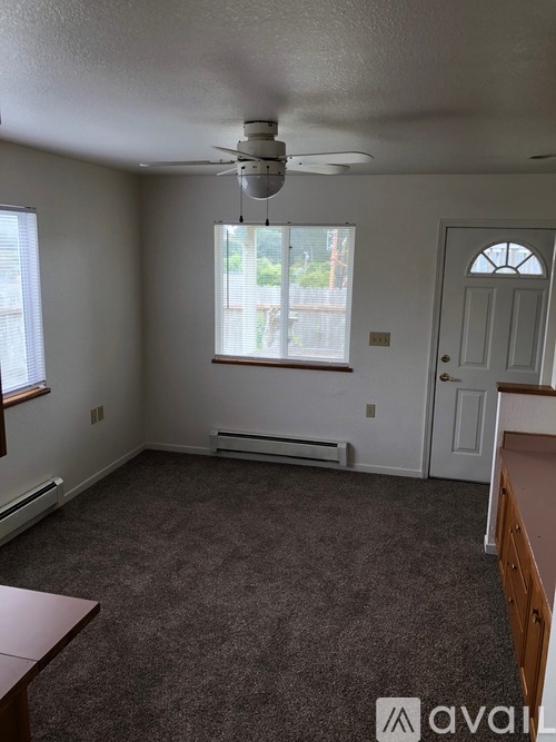 A room with a ceiling fan and a window with blinds.