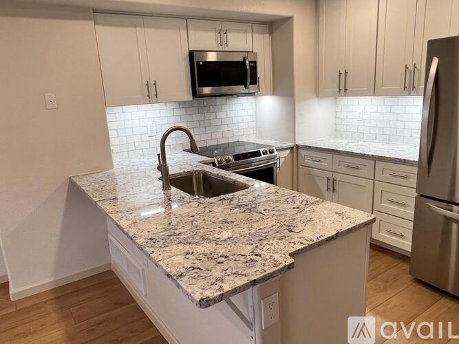 A kitchen with granite countertops and stainless steel appliances.