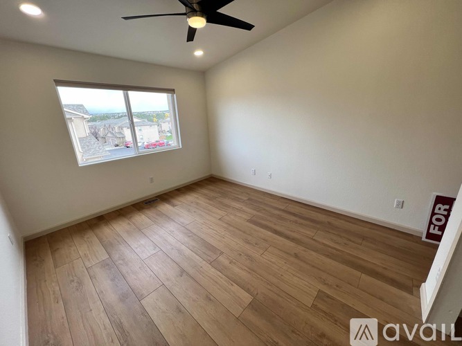 A room with a ceiling fan and wooden flooring is available for rent.