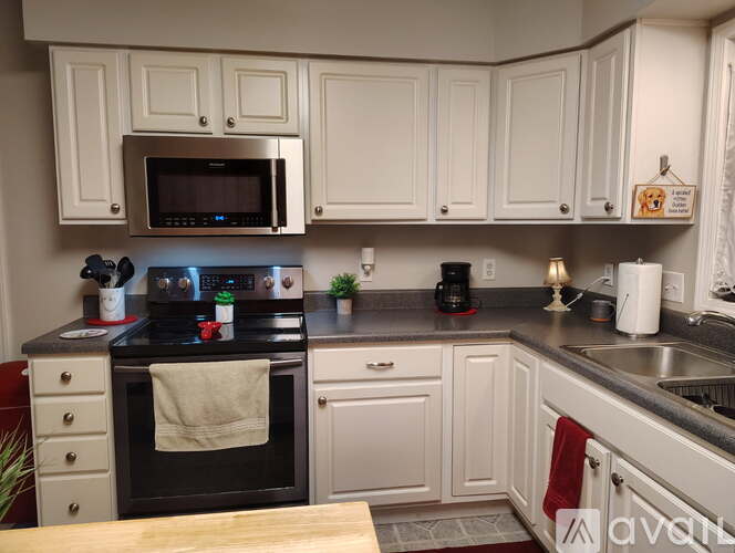 A kitchen with white cabinets and a black stove top.