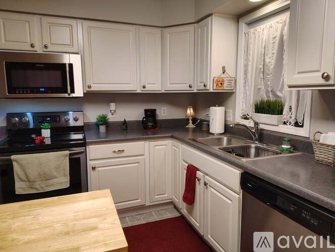 A kitchen with white cabinets and a wooden table.