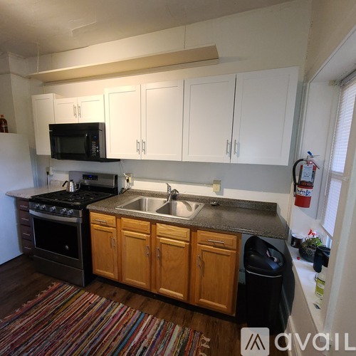 A kitchen with white cabinets and a black stove top oven.