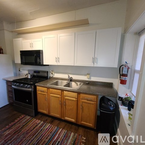 A kitchen with white cabinets and a black stove top oven.