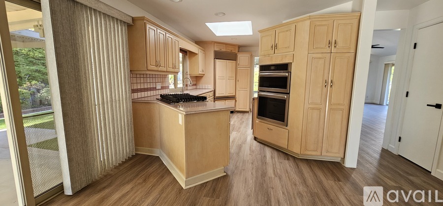 A kitchen with wooden cabinets and a countertop with a sink.