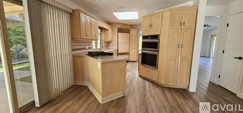 A kitchen with wooden cabinets and a countertop with a sink.