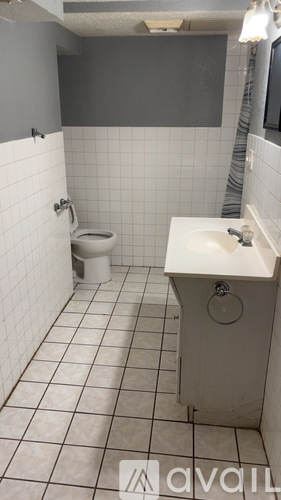 A bathroom with a toilet, sink, and tiled floor.