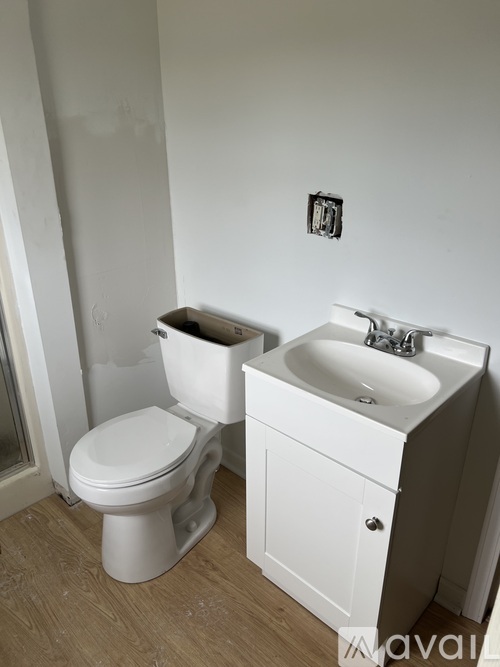 A white toilet and sink in a bathroom.