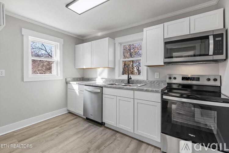 A kitchen with white cabinets and a black stove top oven.