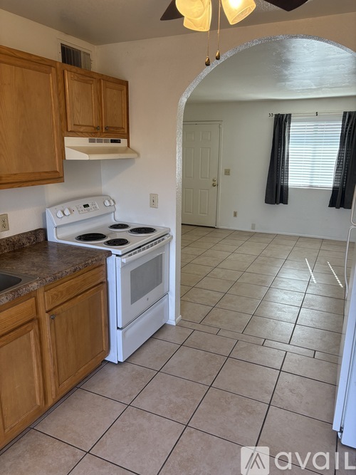 A kitchen with a white stove and wooden cabinets.