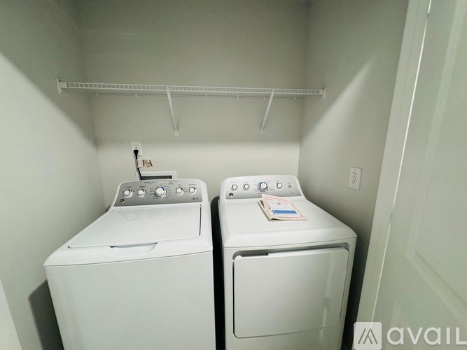 Two white front loading washing machines in a small laundry room.