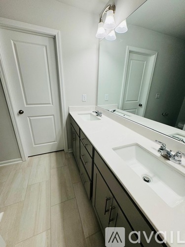 A bathroom with a white sink and a large mirror.