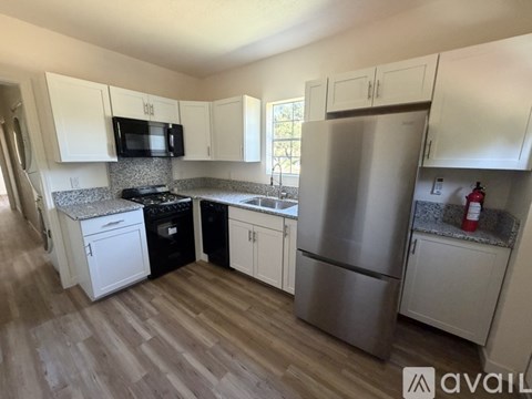 A kitchen with a stainless steel refrigerator, microwave, and oven.