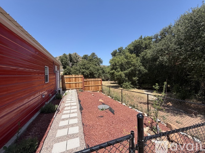 A red building with a black fence and a playground in front.