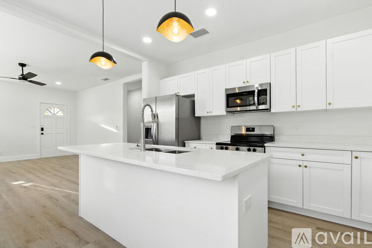 A modern kitchen with white cabinets and a center island.