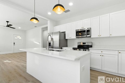 A modern kitchen with white cabinets and a center island.