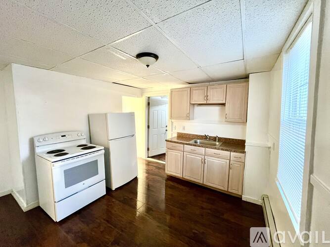 A kitchen with white appliances and wooden cabinets.