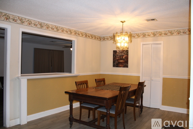 A dining room with a wooden table and chairs.