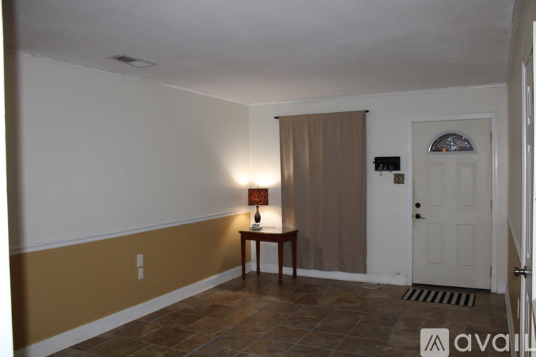A room with a table and a lamp.
