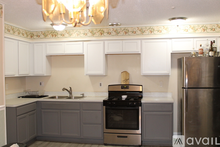 A kitchen with a stove top oven and a refrigerator.