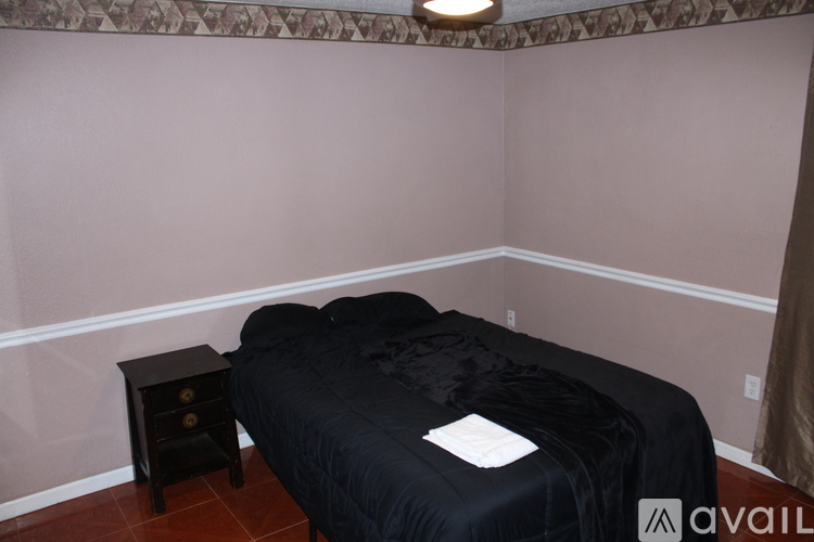 A bedroom with a bed and a small table.