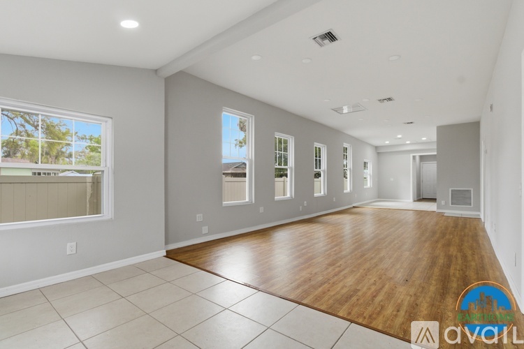 A spacious room with wooden flooring and white walls.