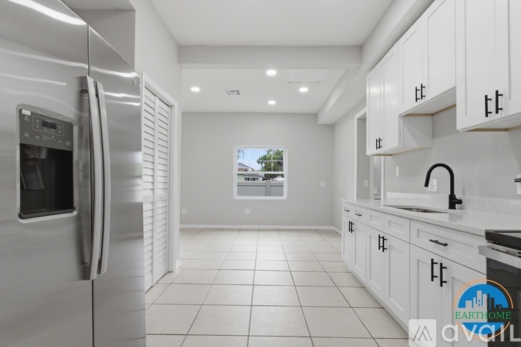 A modern kitchen with white cabinets and a stainless steel refrigerator.