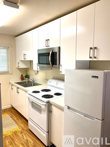 A kitchen with white appliances and cabinets.