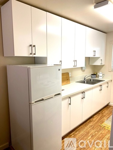 A kitchen with white cabinets and a white fridge.