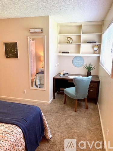 A bedroom with a bed, desk, and chair.