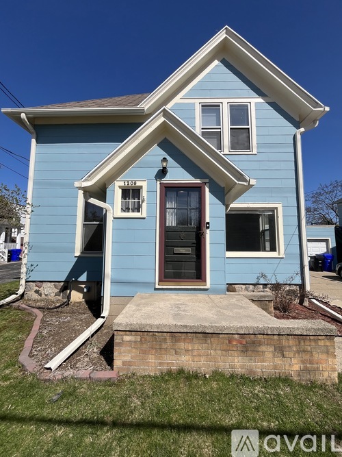 A blue house with a white trim and a brown door.