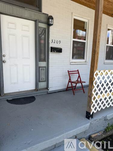A white door with a mailbox on the right side of a porch.