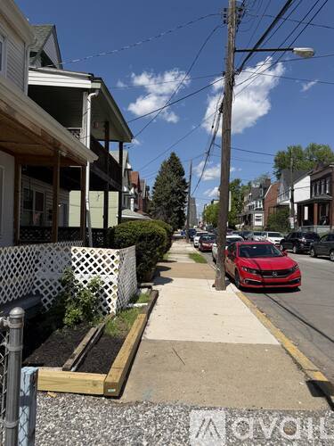 A red car is parked on the side of a street.