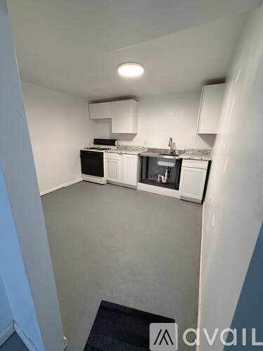 A small kitchen with white cabinets and a black countertop.