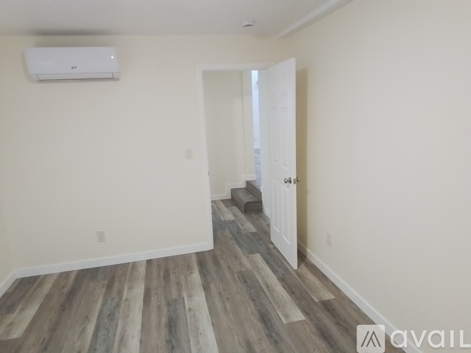 A room with a wooden floor and a white door.