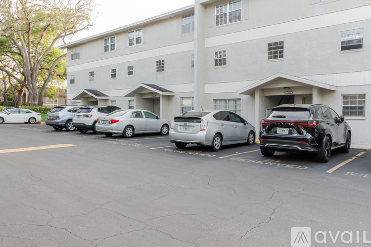 A parking lot with several cars parked in front of a building.