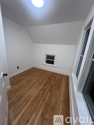 A room with wooden flooring and a window.
