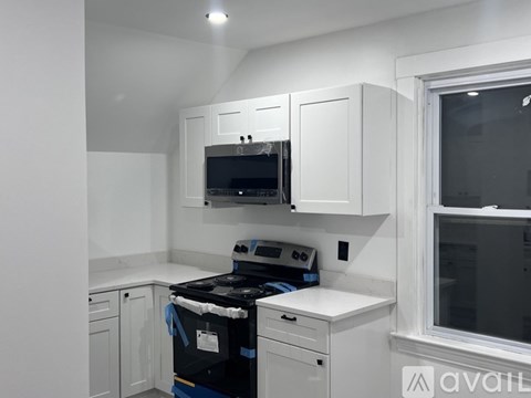 A kitchen with white cabinets and a black stove top oven.