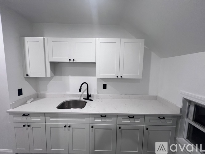 A kitchen with white cabinets and a sink.