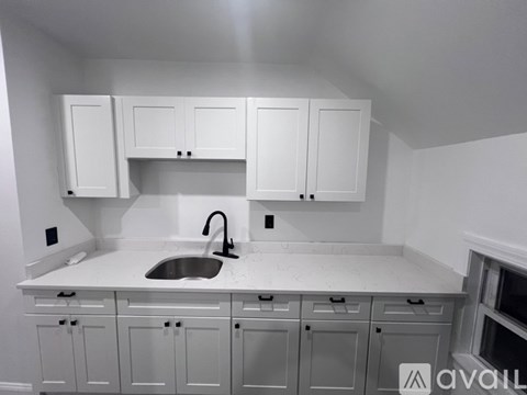 A kitchen with white cabinets and a sink.