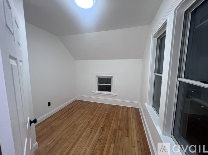 A room with wooden flooring and a window.