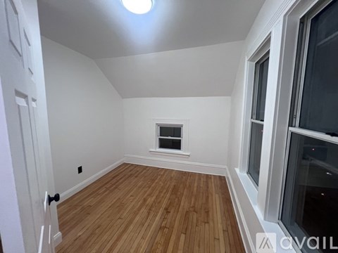 A room with wooden flooring and a window.