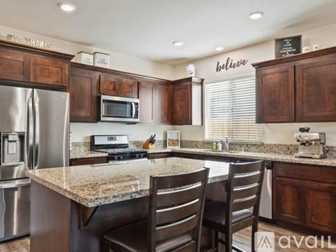 A kitchen with wooden cabinets and a granite countertop.