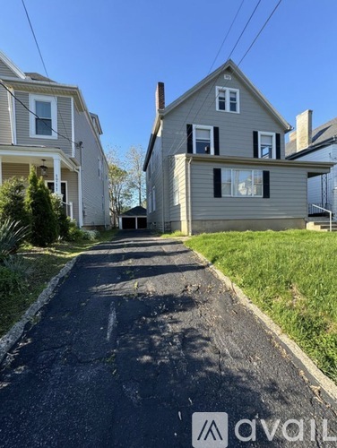 A residential street with houses on both sides and a clear sky.